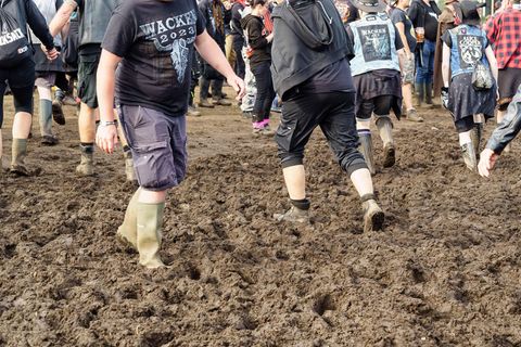 Fans laufen auf dem Wacken-Festival mit Gummistiefel durch den Schlamm
