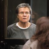 Ein älterer Mann hinter einer Glasscheibe