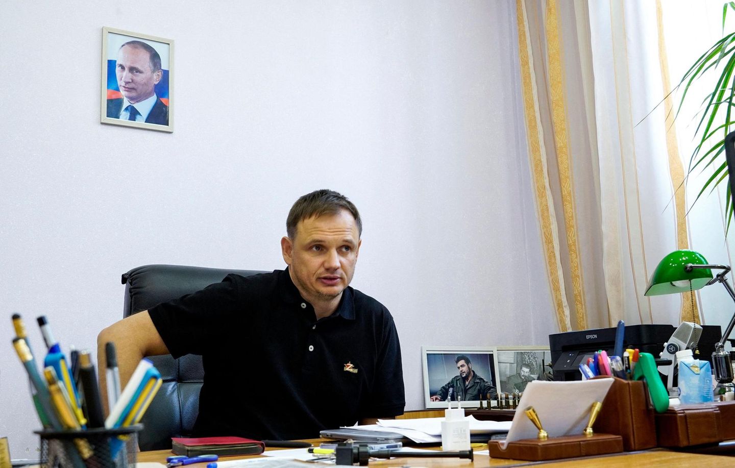 Stremousov an einem Schreibtisch und an der Wand ein Bild von Putin Stremousov an einem Schreibtisch und an der Wand ein Bild von Putin