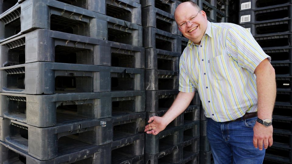 Plastikpaletten der Industrie werden nach ihrem Lebensende als neue Paletten wiedergeboren. Christoph Brüning zeigt auf die aufgebrochenen Füße der Palette, die Styropor enthalten, das herausgefiltert werden muss.  