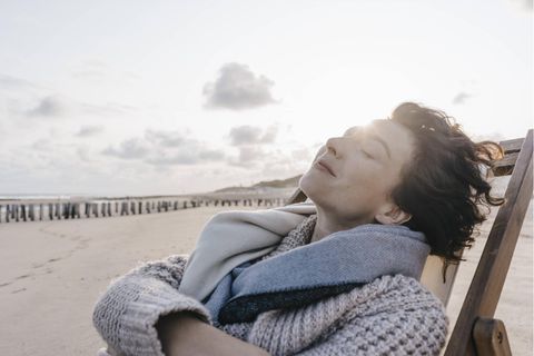 Urlaub: Eine Frau liegt mit geschlossenen Augen auf einem Liegestuhl