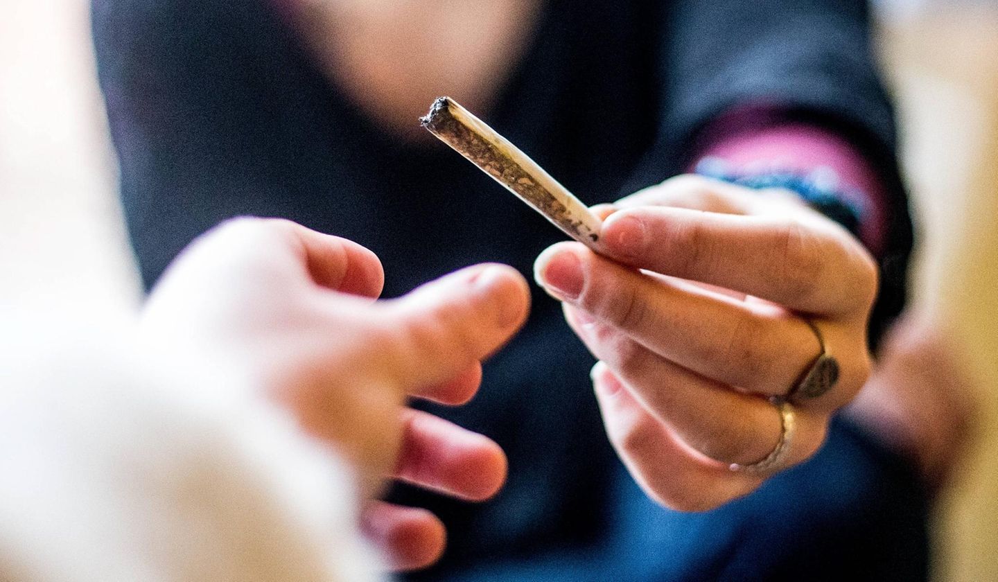 Zwei Personen teilen sich einen Joint