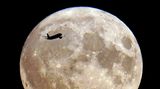 Ein Flugzeug fliegt vor dem "Blue Moon" in London entlang