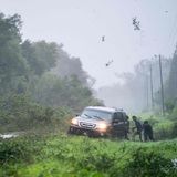 Menschen daran, ein Fahrzeug zu befreien, das inmitten von Sturmtrümmern auf dem Seitenstreifen stecken geblieben ist