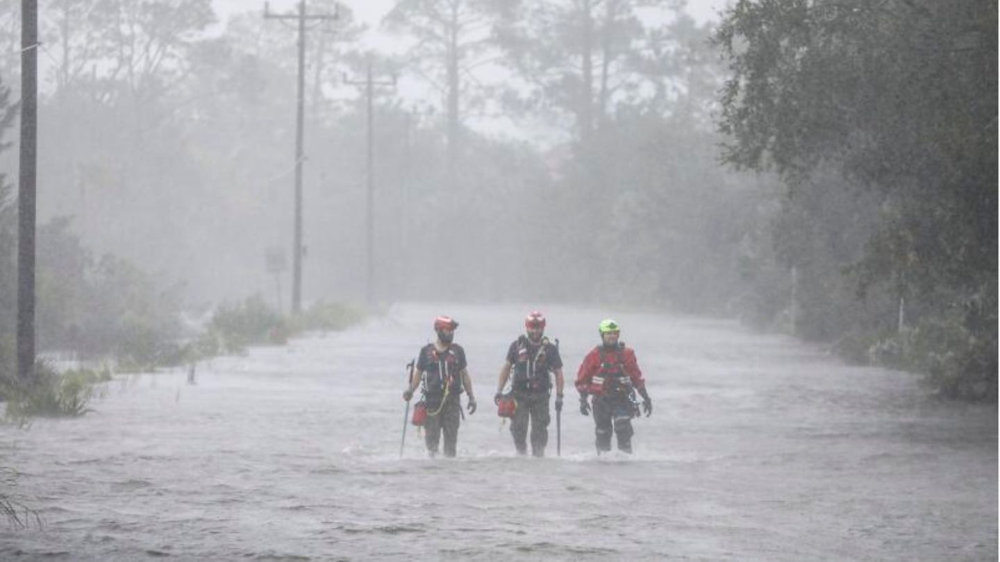 Rettungskräfte von Tidewater Disaster Response waten auf der Suche nach hilfsbedürftigen Menschen durch das Hochwasser