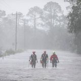 Rettungskräfte von Tidewater Disaster Response waten auf der Suche nach hilfsbedürftigen Menschen durch das Hochwasser