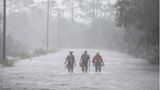 Rettungskräfte von Tidewater Disaster Response waten auf der Suche nach hilfsbedürftigen Menschen durch das Hochwasser