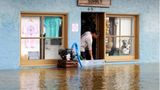 Ein Ladenbesitzer in Tarpon Springs versucht mit einer Sumpfpumpe, das Wasser aus seinem Laden fernzuhalten