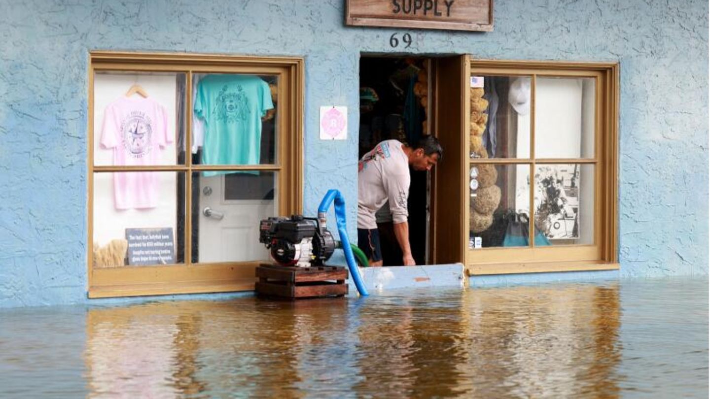 Ein Ladenbesitzer in Tarpon Springs versucht mit einer Sumpfpumpe, das Wasser aus seinem Laden fernzuhalten