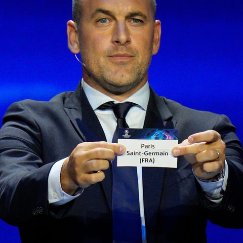 Der ehemalige Fußballspieler Joe Cole zeigt ein Los von Paris Saint-Germain