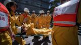 Mitarbeiter der Mori Building Company führen am Katastrophenschutztag ein Notfall-Training durch