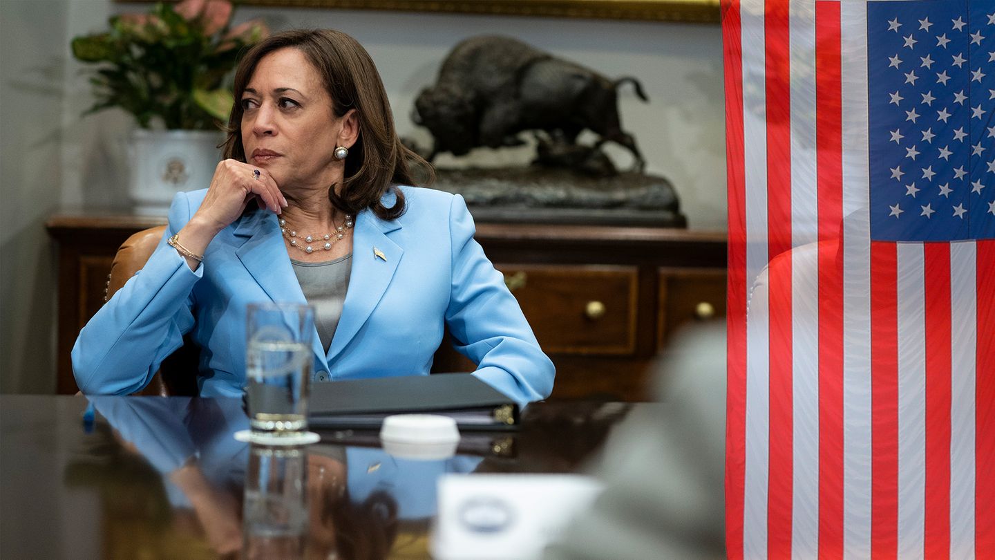 Kamala Harris sitzt an einem großen Besprechungstisch am Kopfende
