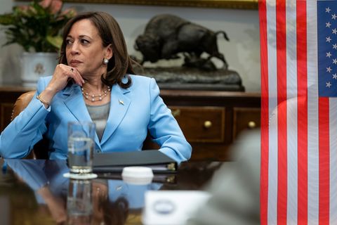 Kamala Harris sitzt an einem großen Besprechungstisch am Kopfende
