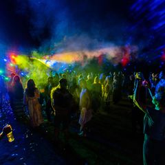 Menschen tanzen vor einer beleuchteten Bühne