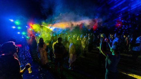 Menschen tanzen vor einer beleuchteten Bühne