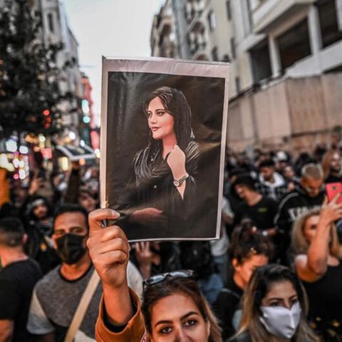 Eine Frau demonstriert mit einem Foto der getöten Mahsa Amini in Istanbul.