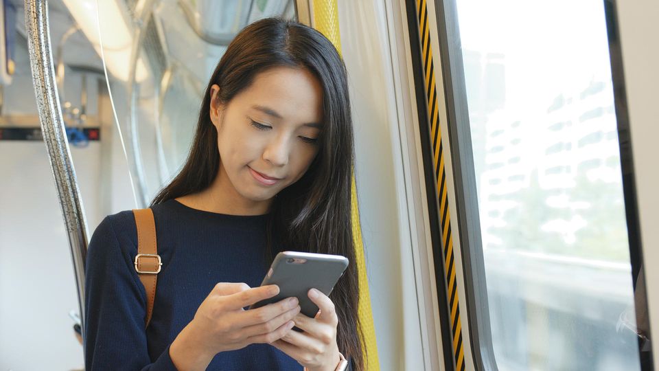 Deutsche Bahn: Eine Frau steht im Zug und hält ein Handy in der Hand