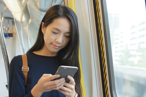 Deutsche Bahn: Eine Frau steht im Zug und hält ein Handy in der Hand