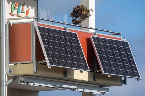 Solarmodule für ein sogenanntes Balkonkraftwerk hängen an einem Balkon