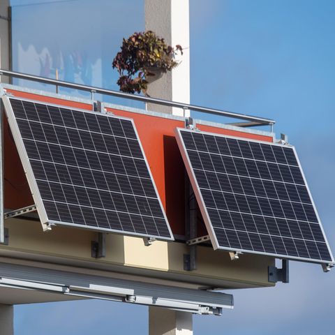 Solarmodule für ein sogenanntes Balkonkraftwerk hängen an einem Balkon