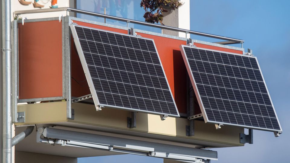 Solarmodule für ein sogenanntes Balkonkraftwerk hängen an einem Balkon