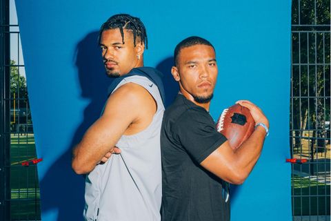 Equanimeous und Amon-Ra St. Brown stehen mit dem Rücken gegeneinander gelehnt vor einer blauen Matte