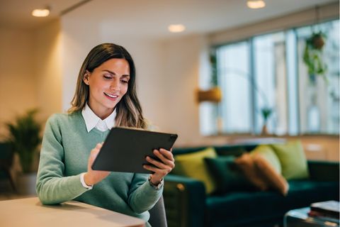 Eine Frau liest an ihrem Tablet bis 200 Euro