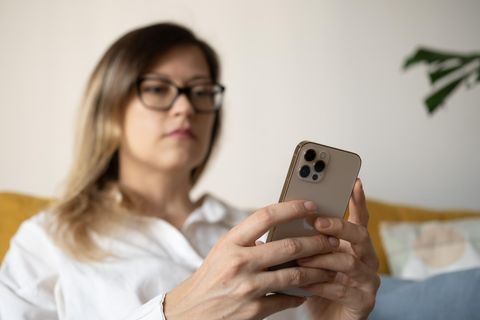 Frau hält ein iPhone in der Hand