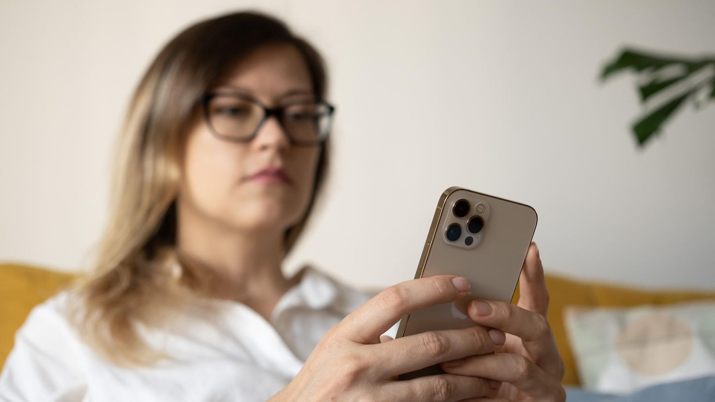 Frau hält ein iPhone in der Hand