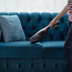 Eine Frau saugt eine Couch ab