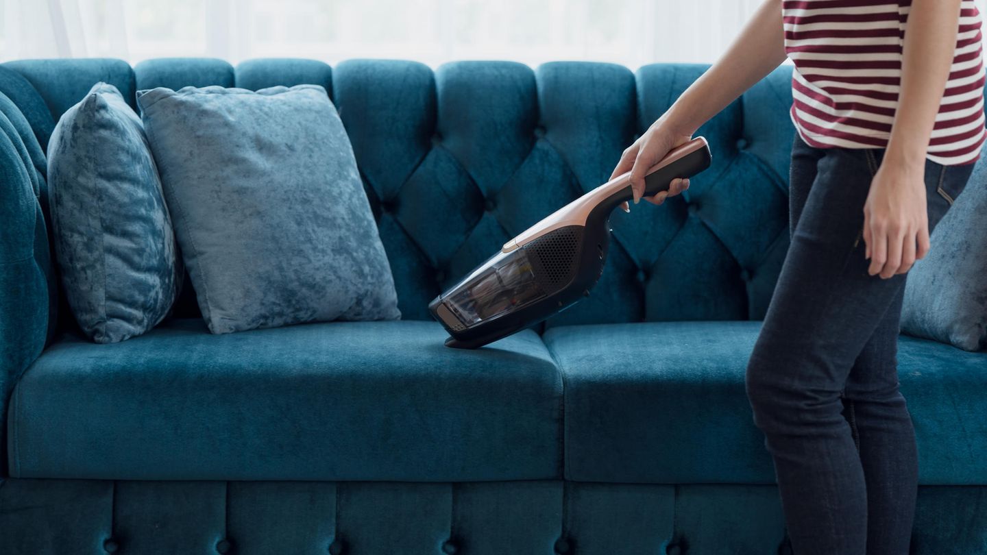 Eine Frau saugt eine Couch ab