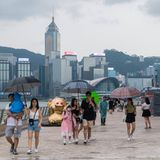 Familien laufen über eine Straße in Hongkong