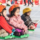Kinder in Busan, Südkorea, werden auf Schlitten über eine Eisbahn gezogen