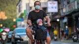 In Taiwan fährt ein Vater mit seinem Kind auf dem Roller