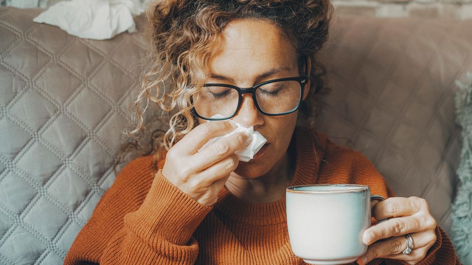 Coronavirus: Eine Frau hält sich ein Taschentuch vor die Nase
