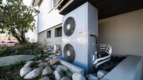 Zankapfel grüne Heizenergie: Lüftungsanlage einer Wärmepumpe an einem Wohnhaus
