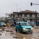 Ein Auto fährt über eine von Trümmern bedeckten Straße in Volos, Griechenland. Inzwischen herrscht dort ein Fahrverbot
