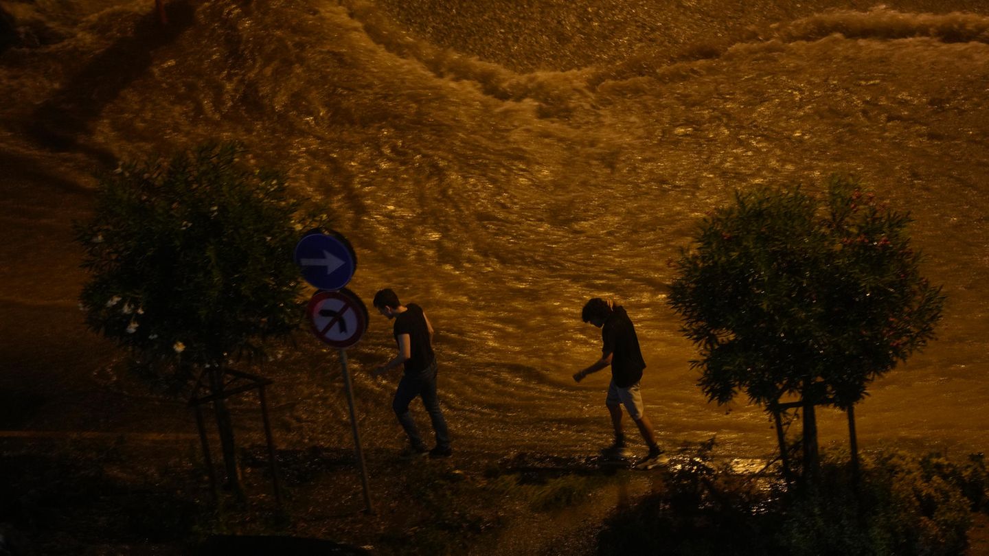 Menschen gehen am Rande einer überfluteten Straße in Istanbul entlang