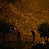 Menschen gehen am Rande einer überfluteten Straße in Istanbul entlang