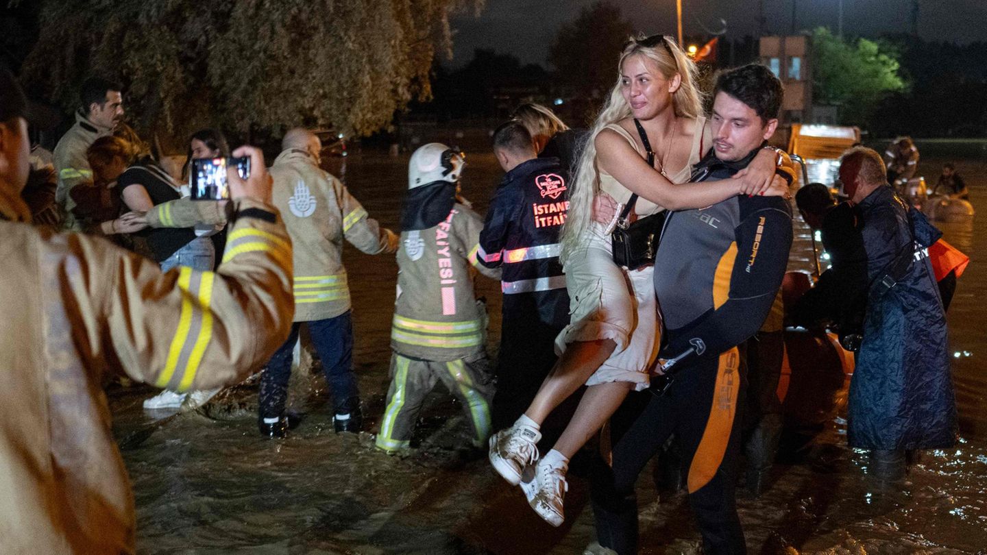 Ein Retter evakuiert eine Frau in Istanbul per Muskelkraft