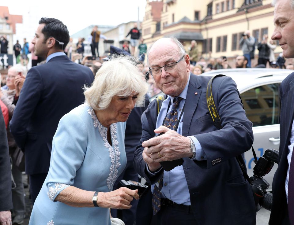 Photographer Edwards shows Queen Camilla a photo on his cell phone Photographer Edwards shows Queen Camilla a photo on his cell phone