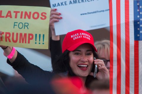 Ein Frau trägt eine Kappe auf der steht "Make America Great Again". Sie hält ein Schild, auf dem Steht: "Latinos for Trump"