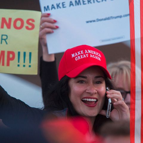 Ein Frau trägt eine Kappe auf der steht "Make America Great Again". Sie hält ein Schild, auf dem Steht: "Latinos for Trump"
