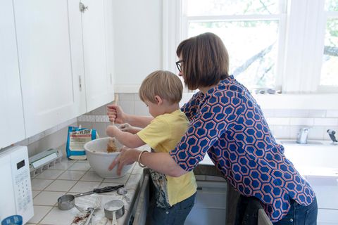 Eine Mutter steht mit ihrem kleinen Sohn in der Küche und backt etwas mit ihm
