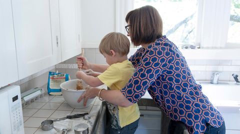 Eine Mutter steht mit ihrem kleinen Sohn in der Küche und backt etwas mit ihm
