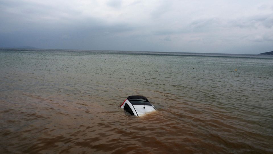 Griechenland: Ein Auto ist nach einem Rekordregen halb im Meer versunken