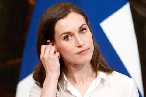 Sanna Marin fasst sich während einer Pressekonferenz ans Ohr