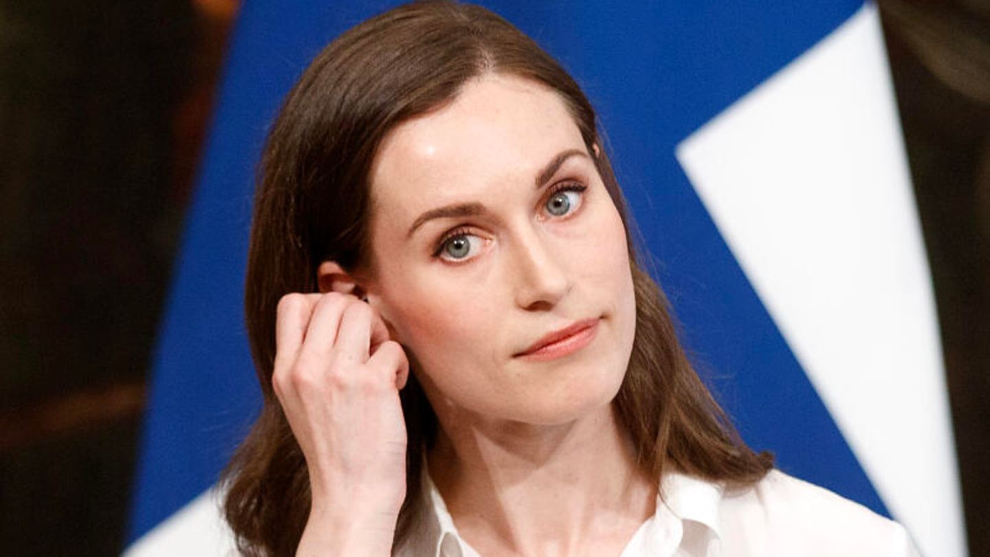 Sanna Marin fasst sich während einer Pressekonferenz ans Ohr