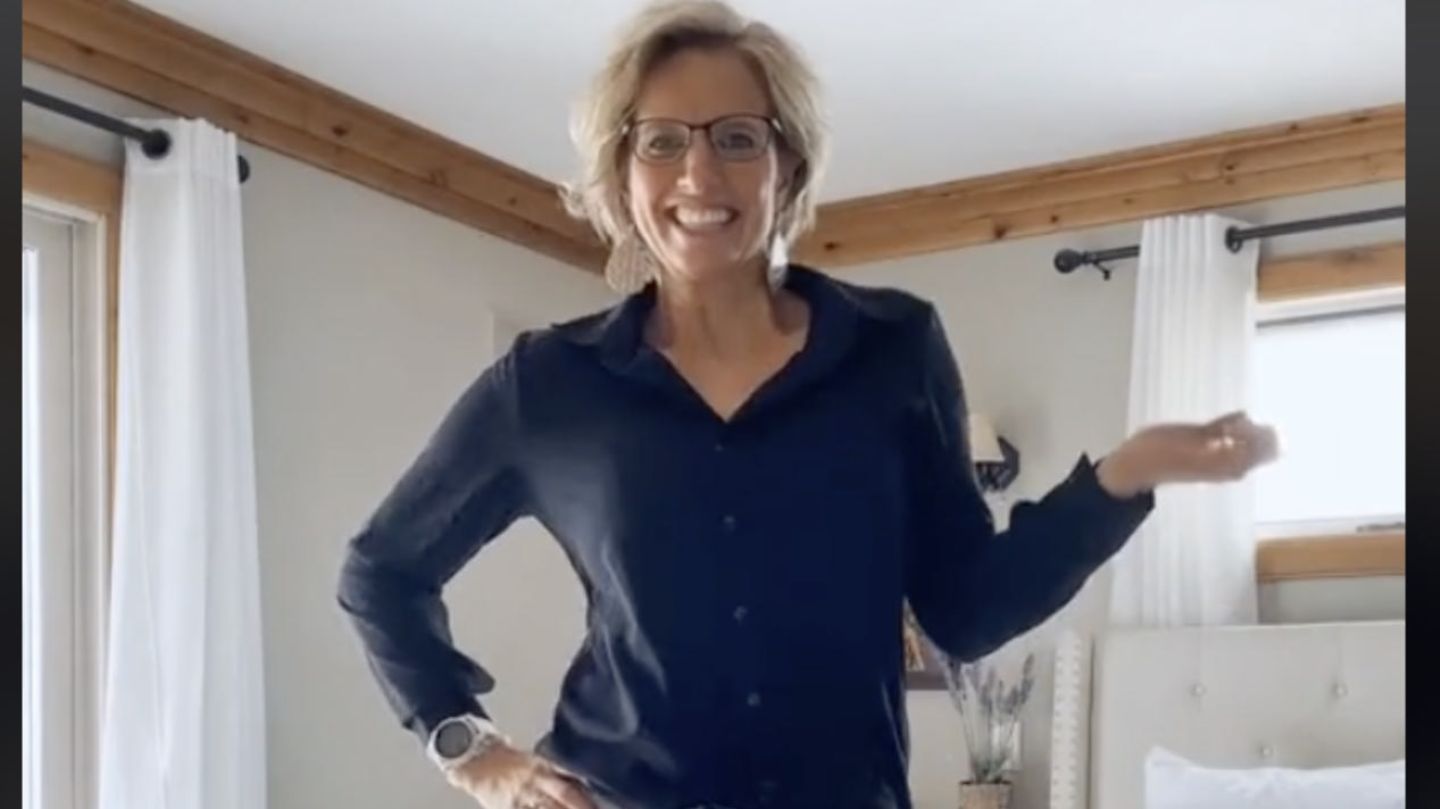 Eine Frau zeigt sich via Tiktok und strahlt in die Kamera