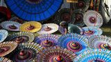 Solo, Java. Ein Handwerker zeigt die Herstellung eines traditionellen Sonnenschirms aus Stoff und Bambus während des Indonesia Parasol Festival 2023